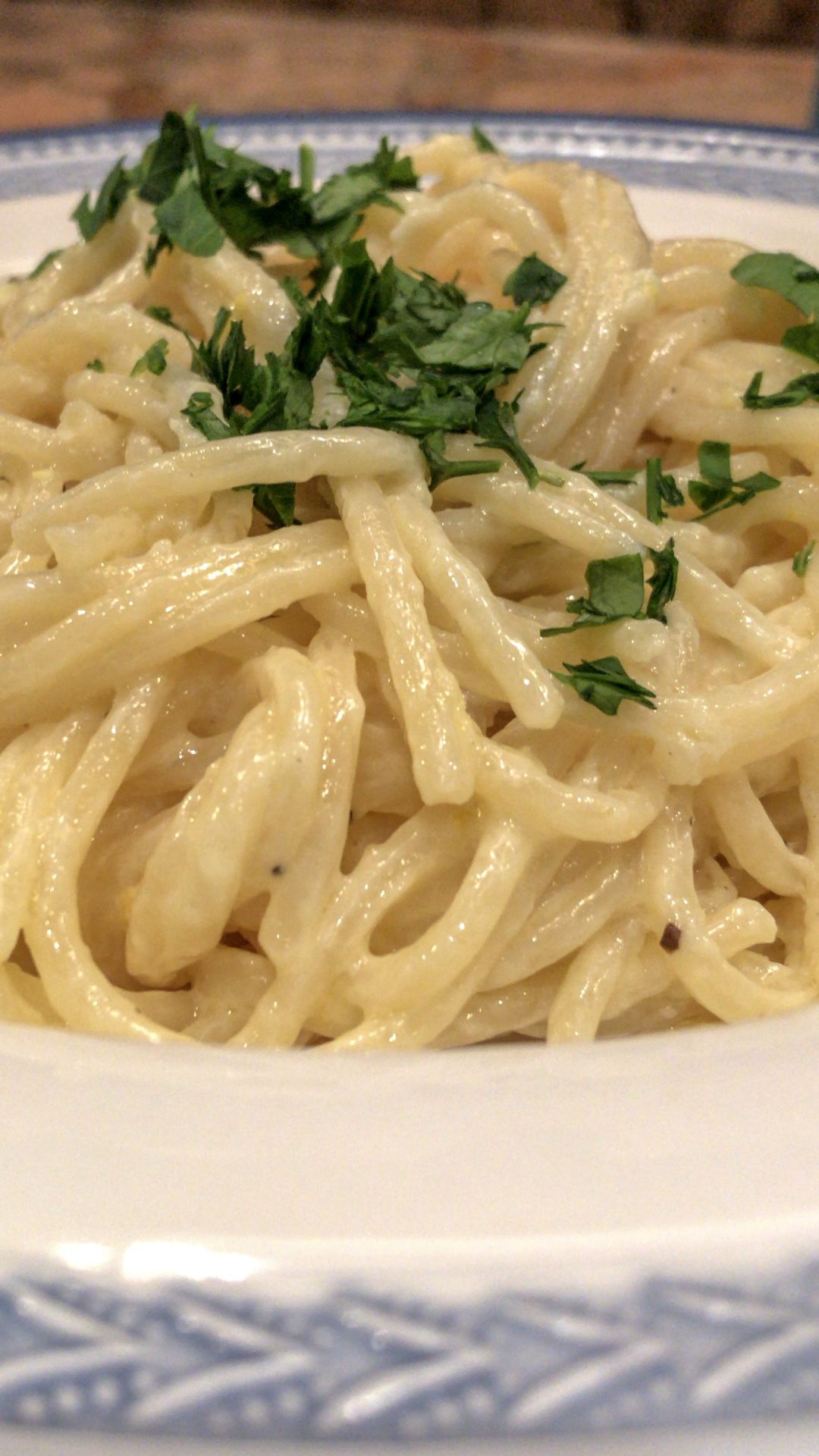 side-view closeup of fettuccine Alfredo garnished with cilantro