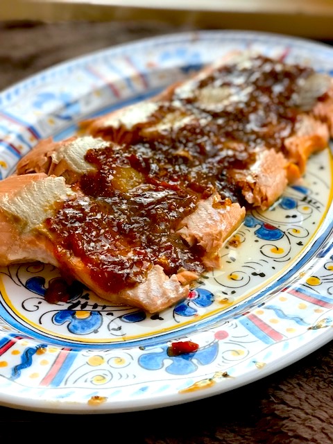 side view of salmon slices on a platter topped with a chili-mustard glaze