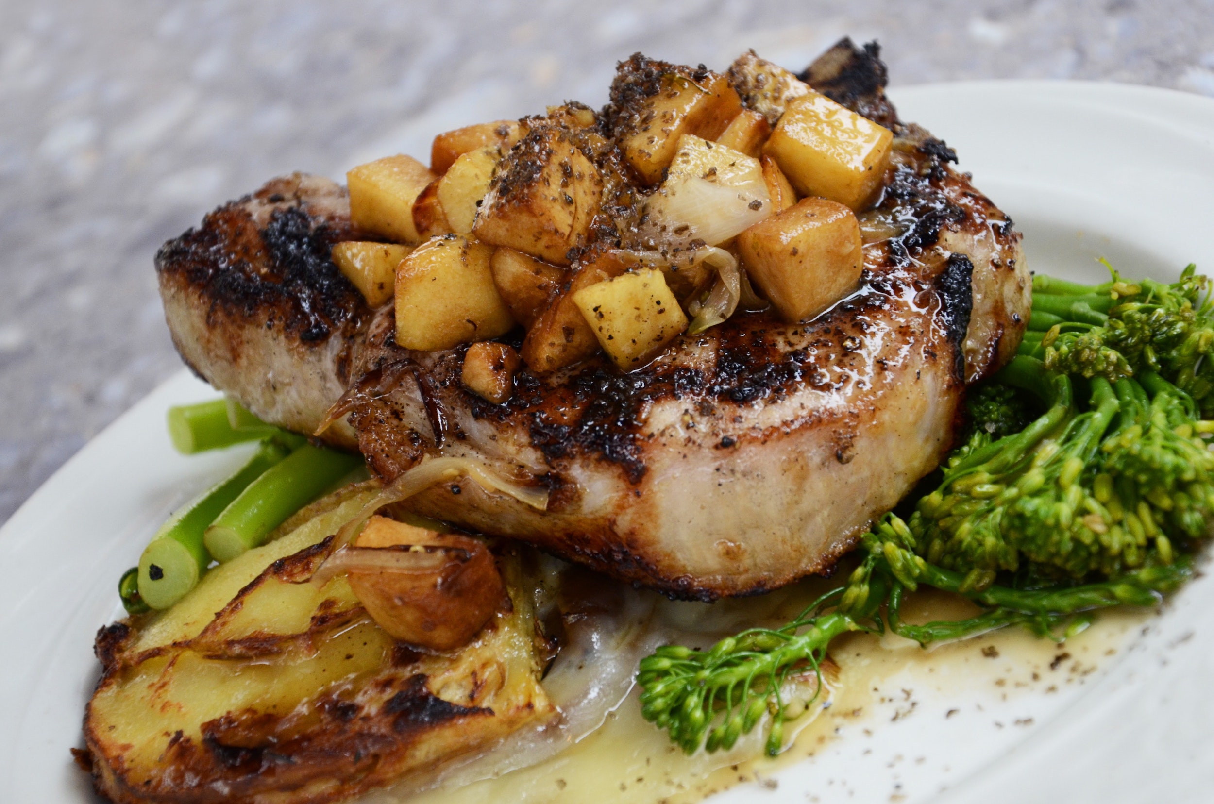 overhead shot of pork on a white plate with fennel