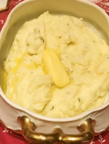 mashed potatoes in a bowl with melted butter on top