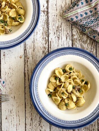 overhead of orecchiette pasta with peas and prosciutto in a bowl