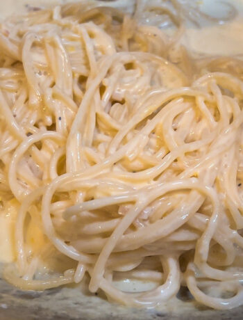 overhead of spaghetti in a creamy sauce in a pan