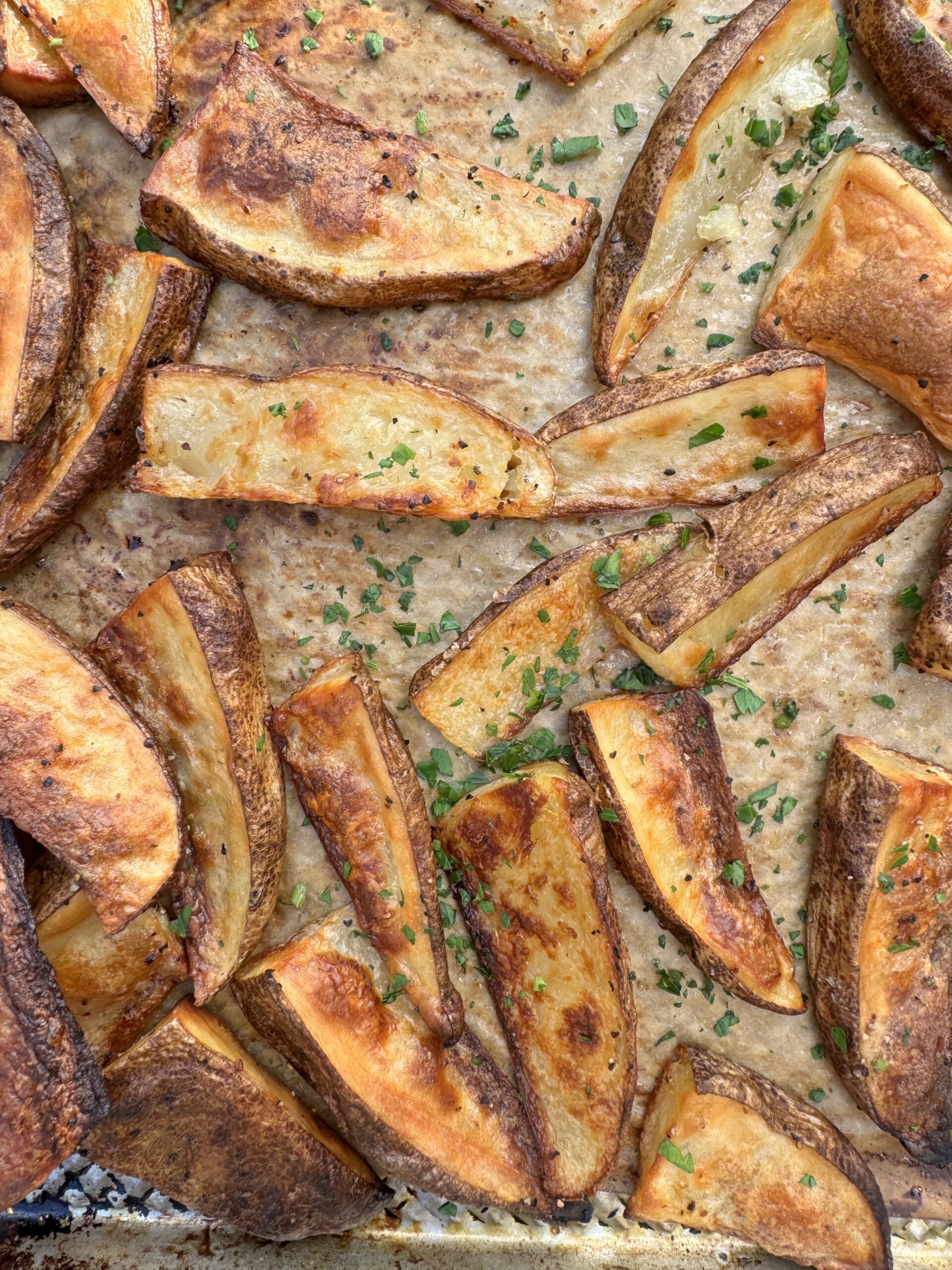 overhead photo of crispy baked potato wedges on sheet pan