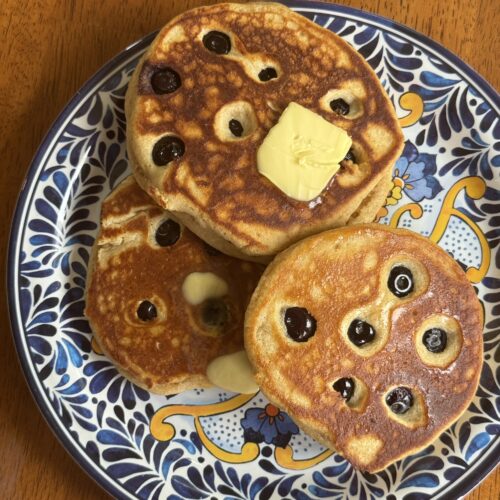 Overhead photo of kodiak pancakes with blueberries on blue patterned plate