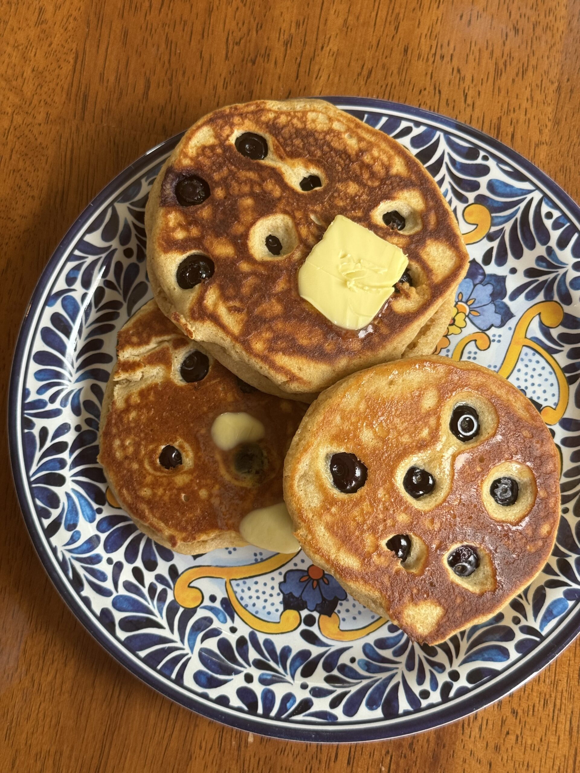 Overhead photo of kodiak pancakes with blueberries on blue patterned plate