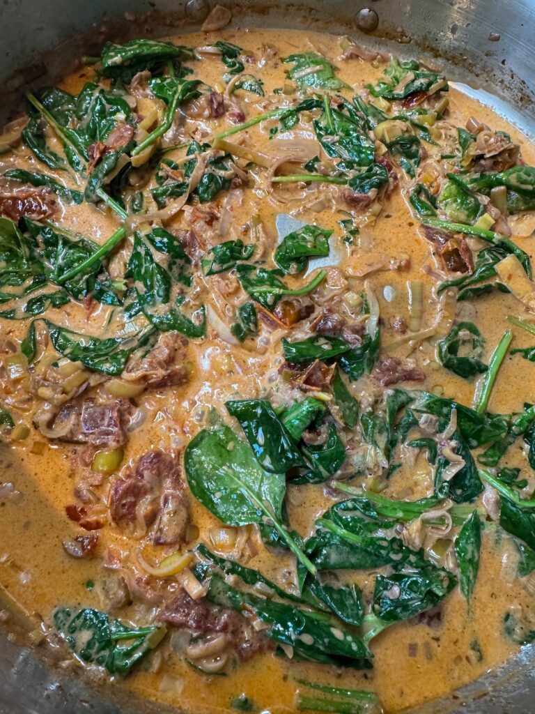 sundried tomato and spinach sauce in skillet