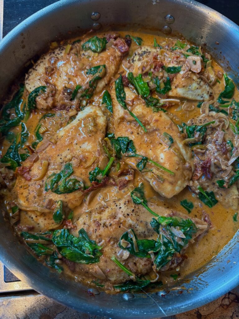 chicken in sundried tomato and spinach sauce in skillet